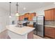 Eat-in kitchen with stainless steel appliances, wood cabinets, and stone backsplash at 519 Cadiz Dr, Davenport, FL 33837