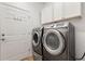 Convenient laundry room featuring modern washer and dryer, white cabinets, and a door to the exterior at 519 Cadiz Dr, Davenport, FL 33837