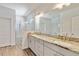 Bathroom with double vanity, marble countertops, a large mirror, and a glass shower with tile surround at 5627 Orange Orchard Dr, Winter Garden, FL 34787