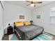 Bedroom with wood floors and ceiling fan features a bed with yellow pillows and stylish rug at 5627 Orange Orchard Dr, Winter Garden, FL 34787