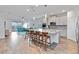 Open-concept kitchen showcasing an expansive island with seating, modern appliances, and seamless flow to the living area at 5627 Orange Orchard Dr, Winter Garden, FL 34787