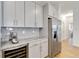 Kitchen area with modern appliances, sleek gray cabinetry, stainless steel refrigerator, and granite countertops at 5627 Orange Orchard Dr, Winter Garden, FL 34787