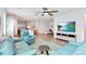 Spacious living area showcasing hardwood floors, comfortable seating, a ceiling fan, and seamless flow into the open kitchen at 5627 Orange Orchard Dr, Winter Garden, FL 34787