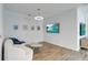 Bright living room features wood floors, contemporary lighting, modern furniture and a wall-mounted television at 5627 Orange Orchard Dr, Winter Garden, FL 34787