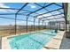Inviting screened-in pool area featuring a refreshing swimming pool with relaxing in-pool seating and a modern privacy wall at 5627 Orange Orchard Dr, Winter Garden, FL 34787