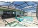 Backyard pool with spa and in-pool loungers inside of a screened enclosure, with house in the background at 5627 Orange Orchard Dr, Winter Garden, FL 34787