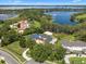 Aerial view of an estate home with a lake view, pool, sport court, and lush landscaping at 5801 Marleon Drive Marleon Drive, Windermere, FL 34786