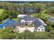 Lakeside estate with a basketball court, pool, and multiple structures amidst mature trees and lush grounds at 5801 Marleon Drive Marleon Drive, Windermere, FL 34786