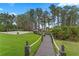 Picturesque backyard with a wooden walkway leading to a volleyball court and lake access at 5801 Marleon Drive Marleon Drive, Windermere, FL 34786