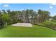 Lush backyard with a sand volleyball court, boardwalk to water, and mature trees at 5801 Marleon Drive Marleon Drive, Windermere, FL 34786