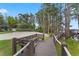 Beautiful backyard featuring a wooden walkway, bench seating, and a volleyball court near the lake at 5801 Marleon Drive Marleon Drive, Windermere, FL 34786