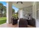 Relaxing covered patio with comfortable seating, stone accent wall, and modern fireplace overlooking a lush green lawn at 5801 Marleon Drive Marleon Drive, Windermere, FL 34786