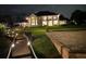 Elegant two-story home featuring a landscaped yard, dock, and beach volleyball area at night at 5801 Marleon Drive Marleon Drive, Windermere, FL 34786