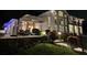 Stunning home exterior with a well-lit patio, lush greenery, and manicured garden at night at 5801 Marleon Drive Marleon Drive, Windermere, FL 34786