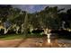 Front yard of a house at night, showing a landscaped lawn and circular driveway with manicured bushes at 5801 Marleon Drive Marleon Drive, Windermere, FL 34786