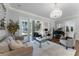 Cozy living room featuring a piano, sofas, and a view of the greenery at 5801 Marleon Drive Marleon Drive, Windermere, FL 34786