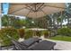 Comfortable lounge seating under a large umbrella near the lake and with views of the volleyball court at 5801 Marleon Drive Marleon Drive, Windermere, FL 34786