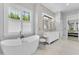 Bright main bathroom offering a soaking tub, glass-enclosed shower, and dual sink vanity with stylish fixtures at 5801 Marleon Drive Marleon Drive, Windermere, FL 34786