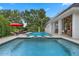 Beautiful pool with stone surround, a statue, seating area, an umbrella, and lush greenery for privacy at 5801 Marleon Drive Marleon Drive, Windermere, FL 34786