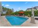 An inground pool has a statue, lounge seating, and umbrellas and is surrounded by lush, green privacy landscaping at 5801 Marleon Drive Marleon Drive, Windermere, FL 34786