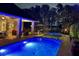 Beautifully lit outdoor pool and patio area with ample seating and hot tub at night at 5801 Marleon Drive Marleon Drive, Windermere, FL 34786