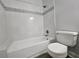Clean white tiled bathtub and shower combination with decorative trim and updated fixtures at 5980 Westgate Dr Dr # 202, Orlando, FL 32835