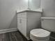 Bathroom features a toilet, white vanity cabinet with granite countertop, and wood-look flooring at 5980 Westgate Dr Dr # 202, Orlando, FL 32835