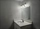 Bathroom vanity with granite countertop, undermount sink, decorative mirror, and modern light fixture at 5980 Westgate Dr Dr # 202, Orlando, FL 32835