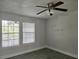 Bright bedroom with two windows and a ceiling fan at 5980 Westgate Dr Dr # 202, Orlando, FL 32835