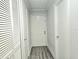 Clean hallway with grey wood-look flooring, white walls, and neutral doors at 5980 Westgate Dr Dr # 202, Orlando, FL 32835