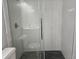 Modern bathroom with tiled shower featuring a glass door and dark-colored tiled floor at 5980 Westgate Dr Dr # 202, Orlando, FL 32835