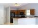 Well-lit kitchen with dark appliances, wooden cabinets, and a breakfast bar at 6500 Abercrombie Ct, Orlando, FL 32835