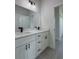 Modern bathroom features a dual sink vanity with white cabinets and black hardware at 6516 Sw 149 Th Lane Rd, Ocala, FL 34473