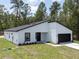 Stylish single-story home with a modern design, a black door, and a two-car garage at 6516 Sw 149 Th Lane Rd, Ocala, FL 34473