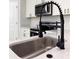 Close up of a stylish black faucet and stainless steel sink, with modern appliances at 6516 Sw 149 Th Lane Rd, Ocala, FL 34473