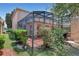 Backyard with a screened-in porch, trees, and bushes for added privacy at 7184 Maleberry Run, Winter Garden, FL 34787