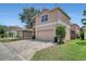 Two-story home with a brick driveway, well-manicured lawn and garden, and an attached two-car garage at 7184 Maleberry Run, Winter Garden, FL 34787