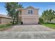 Two-story home with a brick driveway, two-car garage, and exterior stairs to the upper level at 7184 Maleberry Run, Winter Garden, FL 34787