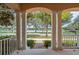Covered front porch with stately columns, showcasing the beautiful neighborhood and tranquil lake at 7184 Maleberry Run, Winter Garden, FL 34787