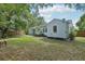 Exterior view of a light blue house with green lawn, trees and fencing at 826 Garden Plz, Orlando, FL 32803
