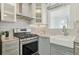 The kitchen features a stainless steel oven and sink with light grey cabinets and stone countertops at 826 Garden Plz, Orlando, FL 32803