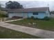 Quaint single-story home with a baby blue exterior, mature landscaping, and a white garage door at 833 Channing Rd, Lakeland, FL 33805