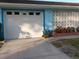 View of the garage door with brick planter and flowers in front at 833 Channing Rd, Lakeland, FL 33805