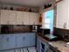 Kitchen featuring upper white cabinets, lower blue cabinets, and decorative tile backsplash at 833 Channing Rd, Lakeland, FL 33805