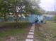A blue storage shed sits among lush trees and landscaping in this home's backyard at 833 Channing Rd, Lakeland, FL 33805