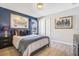 Bedroom with a blue accent wall, closet, and a window that allows natural lighting at 8901 Rhodes St, Kissimmee, FL 34747