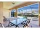 Covered lanai with screen and outdoor dining setup, offering views of the pool at 8901 Rhodes St, Kissimmee, FL 34747