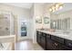 Main bathroom boasting double vanity, glass shower, and access to the private pool at 8901 Rhodes St, Kissimmee, FL 34747