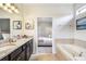 Bright main bathroom with double vanity, soaking tub, and connecting bedroom at 8901 Rhodes St, Kissimmee, FL 34747