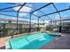 This in-ground swimming pool is surrounded by a screened enclosure and brick pavers at 8901 Rhodes St, Kissimmee, FL 34747